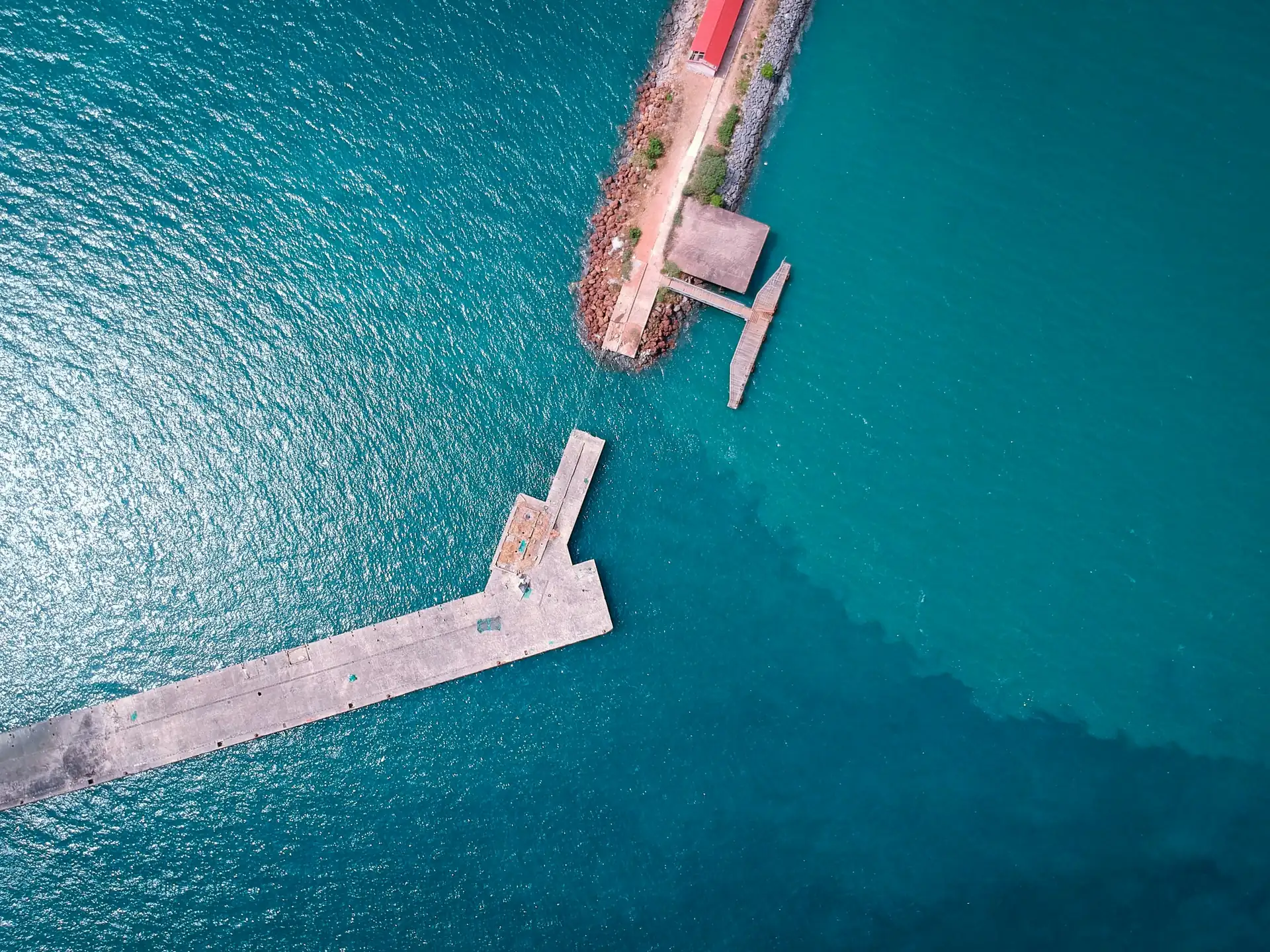 Vue aérienne d'une jetée de béton avançant dans l'océan, à Conakry